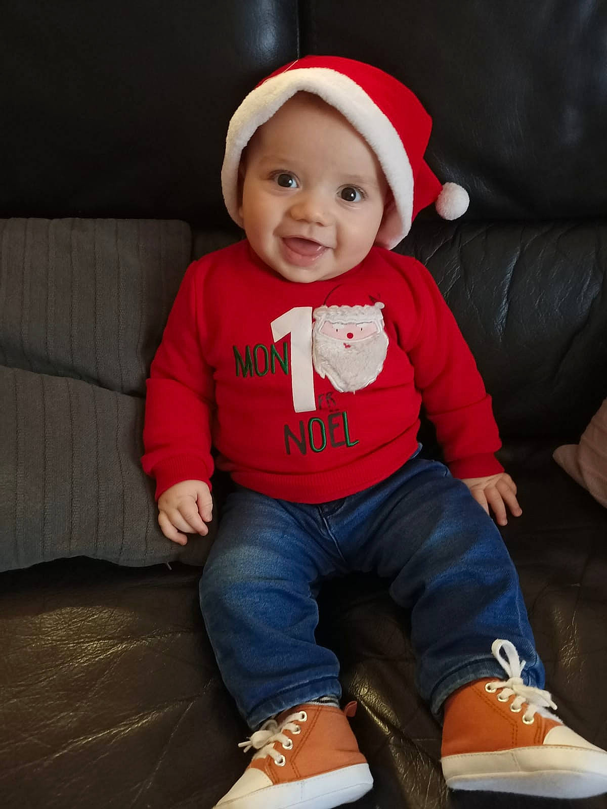 Louis participe au concours pour gagner de l'argent avec cette photo : baby, baby_toddler_clothing, cap, child, clothing, comfort, costume_hat, couch, happy, headwear, human_leg, knee, lap, leg, person, sleeve, smile, sock, t_shirt, thigh