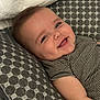 baby, blue_eyes, cheeks, child, closeup, cushion, cute, face, happy, head, indoors, infant, pattern, person, resting, skin, smiling, soft, striped_clothing, young_child