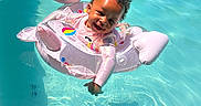 Tarranae is registered to the contest to win money with this photo: toddler, child, pool, water, inflatable, float, swimming, smile, happy, sunlight, outdoor, summer, fun, play, cute, baby, person, recreation, leisure, safety