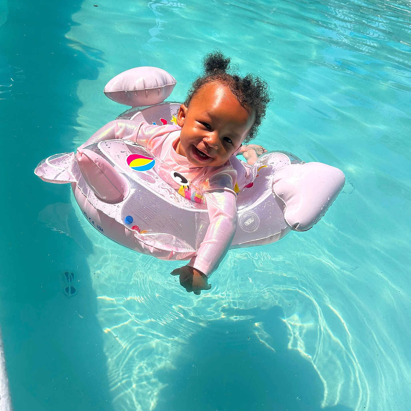 Tarranae is registered to the contest to win money with this photo: toddler, child, pool, water, inflatable, float, swimming, smile, happy, sunlight, outdoor, summer, fun, play, cute, baby, person, recreation, leisure, safety