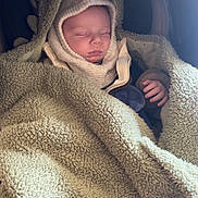 Léo participe au concours pour gagner de l'argent avec cette photo : baby, sleeping, blanket, hood, cozy, warm, infant, child, cute, soft, bundle, rest, peaceful, face, hand, clothing, portrait, indoor, comfort, toddler