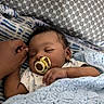Genesis is registered to the contest to win money with this photo: baby, sleeping, pacifier, hand, blanket, knitted, pillow, cozy, infant, rest, peaceful, child, cute, comfort, pattern, soft, portrait, indoor, closeup, toddler