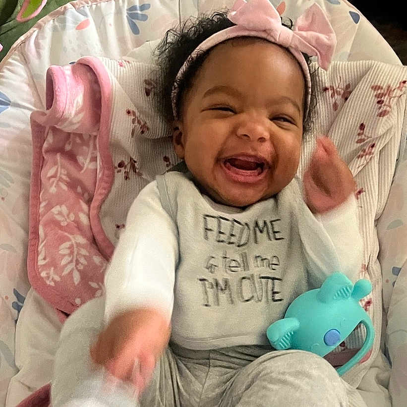 Ailani joined the competition — help win amazing prizes! baby, babylaughing, bed, clothing, crib, cushion, face, furniture, glove, happy, head, homedecor, laughing, newborn, person, photography, portrait, sleeping, t_shirt, toy