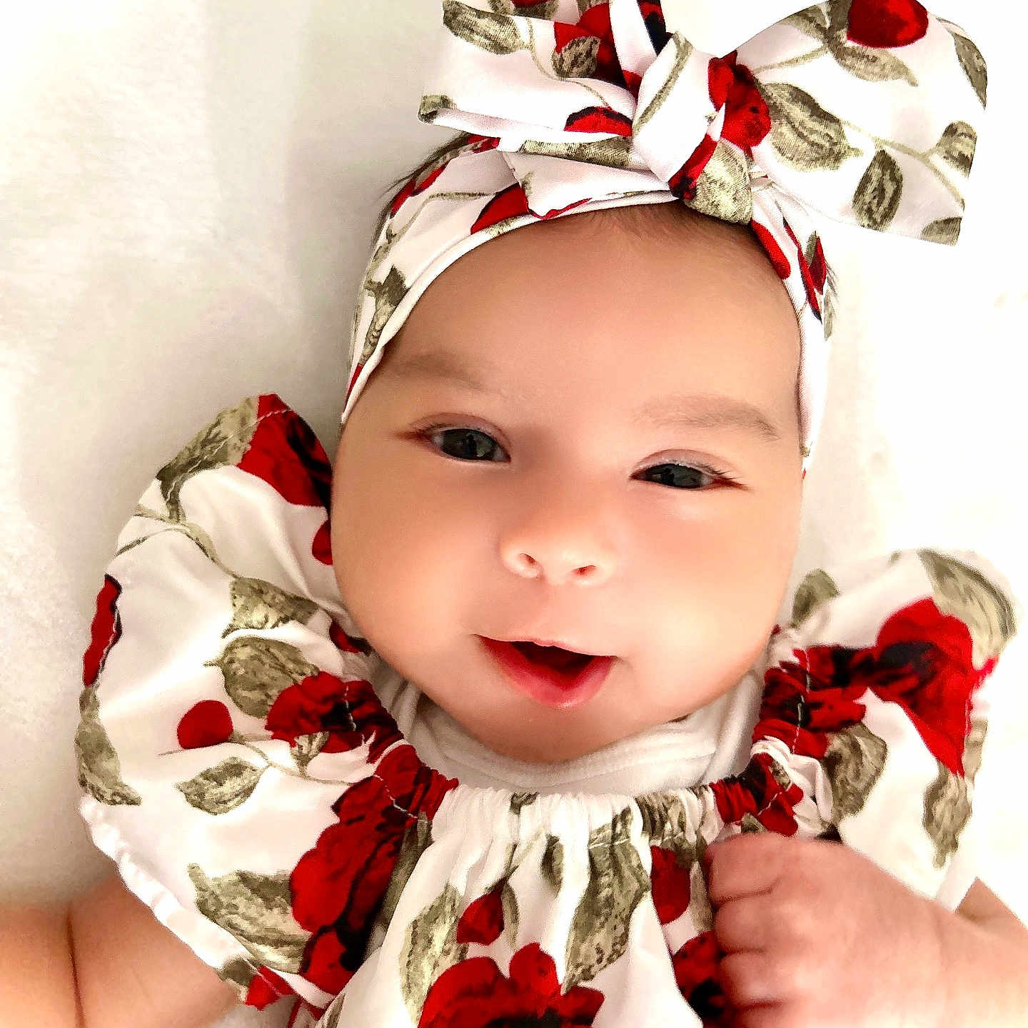 Chrishell Elara joined the competition — help win amazing prizes! baby, child, closeup, cute, dress, eyes, fashion, floral_pattern, hand, happy, headband, indoors, infant, person, portrait, red_roses, skin, smiling, soft_light, white_background