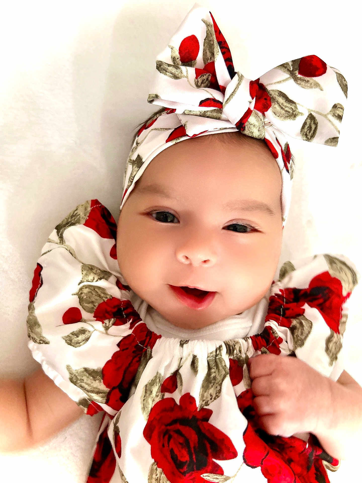Chrishell Elara joined the competition — help win amazing prizes! baby, infant, smiling, headband, dress, floral_pattern, red_roses, cute, portrait, child, happy, closeup, fashion, white_background, soft_light, skin, hand, eyes, person, indoors