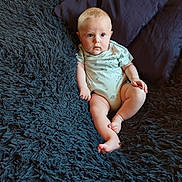 Matthia participe au concours pour gagner de l'argent avec cette photo : baby, infant, child, blue_eyes, plush_blanket, dark_pillow, curious, sitting, indoor, soft_texture, comfort, cute, casual_clothing, light_hair, chubby_legs, portrait, relaxing, home, young, person