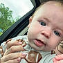 baby, child, face, blue_eyes, onesie, football_pattern, hand, manicure, car, window, outdoor, trees, curious, close_up, infant, person, skin, head, cute, expression