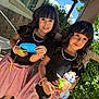 Ashley Y Grace joined the competition — help win amazing prizes! child, girl, outdoor, smile, toy, black_top, pink_skirt, bracelet, necklace, curly_hair, greenery, sunlight, stone_wall, porch, playful, cute, holding, friendship, happy, portrait