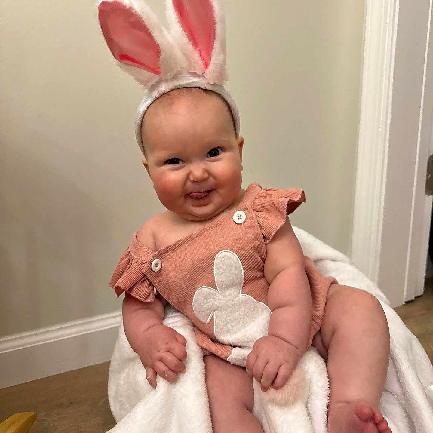 Sayler joined the competition — help win amazing prizes! baby, babylaughing, blanket, bodypart, clothing, costume, dress, face, finger, happy, head, homedecor, indoors, newborn, person, photography, portrait, sitting, smile, towel