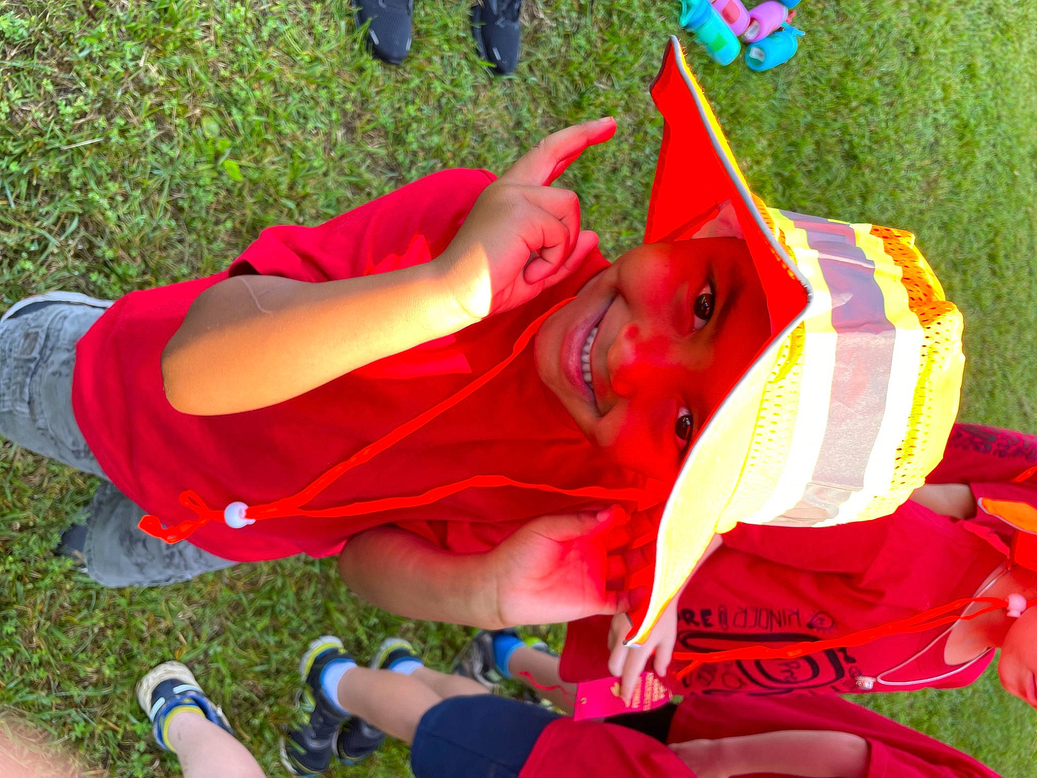 Corbin is registered to the contest to win money with this photo: blue, event, grass, green, happy, headwear, human_leg, joy, lawn, leaf, leg, leisure, people_in_nature, person, pink, recreation, red, shoe, shorts, smile