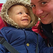 Léon participe au concours pour gagner de l'argent avec cette photo : toddler, child, adult, smile, jacket, hood, outdoor, building, happy, face, person, winter_clothing, closeup, bonding, family, daylight, candid, warmth, interaction, blue_jacket
