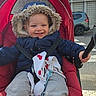 Léon a rejoint le concours — aidez-le/la à gagner de superbes lots ! toddler, child, stroller, jacket, hood, smile, baby, urban, car, building, window, sidewalk, street, red, clothing, happy, seatbelt, outdoor, person, daytime