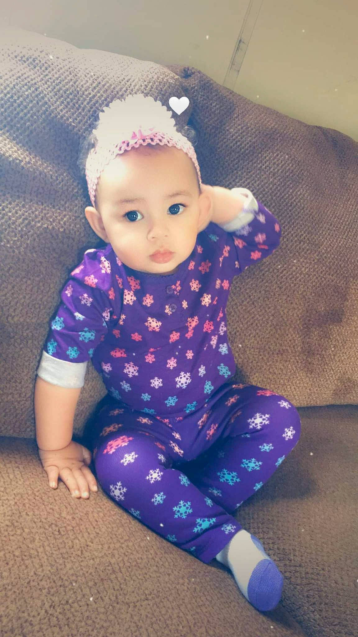 Macii is registered to the contest to win money with this photo: arm, baby, baby_toddler_clothing, cheek, face, finger, flooring, happy, iris, magenta, neck, outerwear, pattern, person, pink, purple, skin, sleeve, t_shirt, toddler
