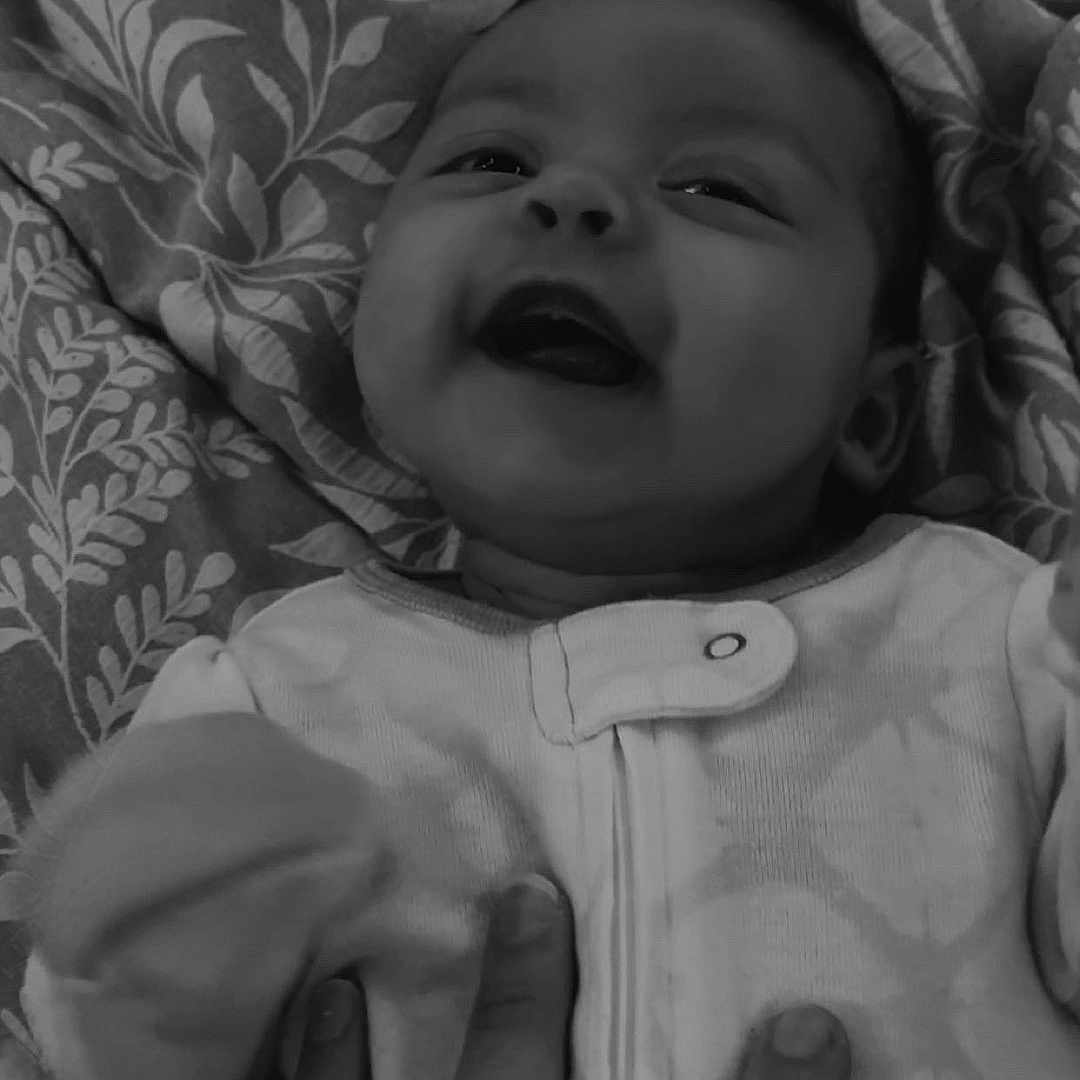 Valentina is registered to the contest to win money with this photo: baby, blanket, child, closeup, clothing, cozy, cute, expression, face, hand, happy, human, infant, lying_down, pattern, playful, portrait, smiling, soft, toddler