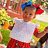 baby, child, portrait, outdoor, backyard, smiling, happy, hair_bows, red_bow, blue_bow, bib, polka_dots, dress, mickey_mouse, corn_on_the_cob, food, garden, deck, railing, family_gathering