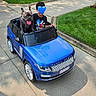 blue_car, child, clothing, curb, daylight, dog, french_bulldog, grass, happy, leash, outdoor, parked_car, pet, play, range_rover, shadows, short_hair, sidewalk, toy_car, vehicle