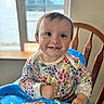 baby, child, colorful_clothing, cute, face, food, food_scraps, hands, happy, high_chair, indoor, meal_time, messy_face, portrait, sitting, smiling, table, toddler, window, wooden_chair
