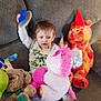 toddler, child, stuffed_animal, unicorn, party_hat, couch, plush_toy, indoor, celebration, toy, bear, cozy, clothing, socks, curious, seated, soft_toy, living_room, wooden_wall, party
