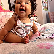 Greeicy joined the competition — help win amazing prizes! baby, child, curly_hair, smiling, happy, bed, blanket, indoor, person, cute, portrait, toddler, clothing, striped_dress, skin, foot, toes, room, soft, cozy
