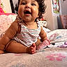 baby, child, curly_hair, smiling, happy, bed, blanket, indoor, person, cute, portrait, toddler, clothing, striped_dress, skin, foot, toes, room, soft, cozy