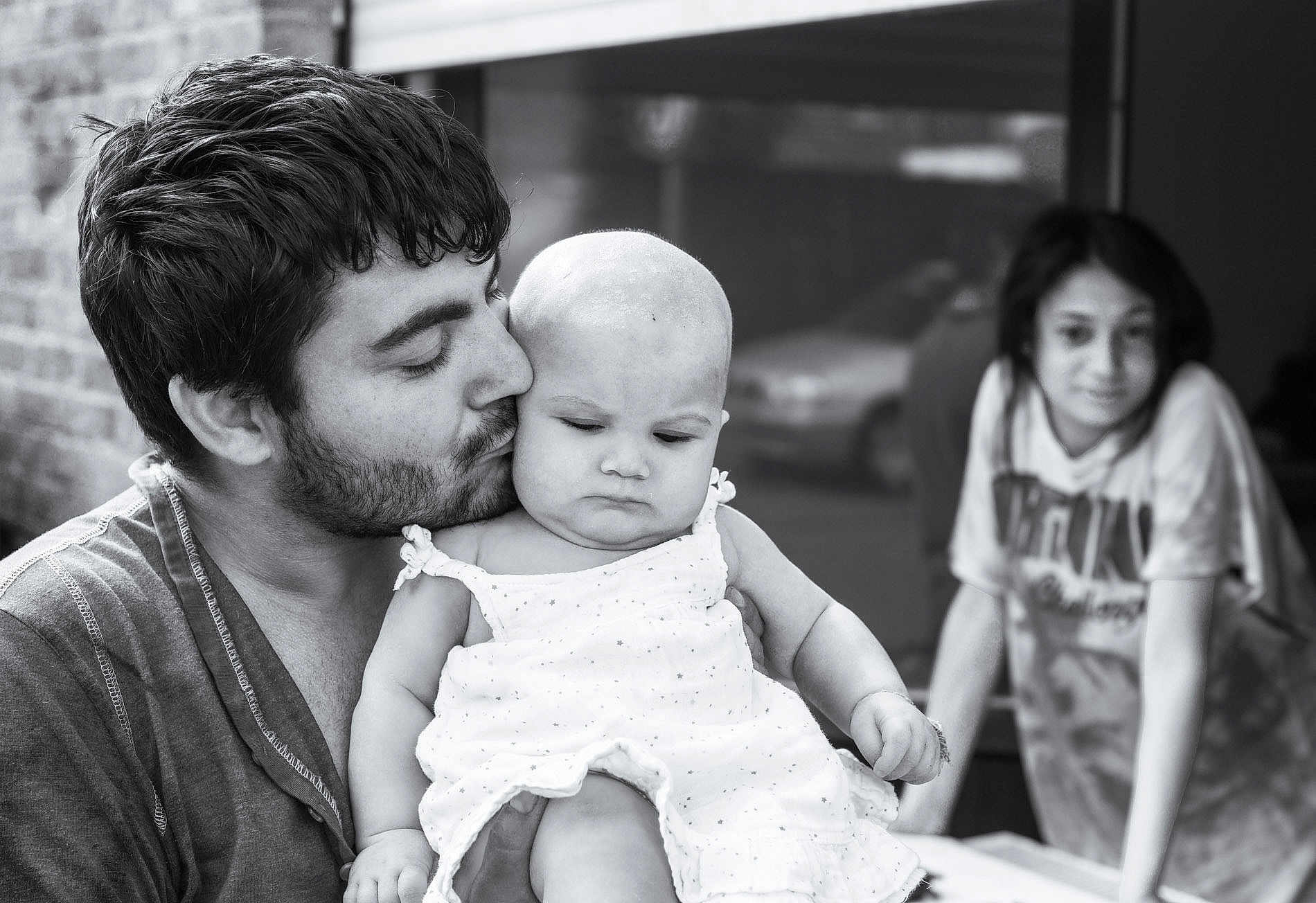 Martocian Leyla participe au concours pour gagner de l'argent avec cette photo : baby, man, child, black_and_white, kiss, family, portrait, love, outdoor, casual_clothing, beard, dress, holding, expression, person, blurred_background, affection, toddler, young_child, candid