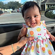 Giselle joined the competition — help win amazing prizes! baby, smiling, child, dress, fruit_pattern, car_interior, hand, tattoo, bracelet, window, daylight, portrait, cute, happy, young_child, person, seat, clothing, skin, hair