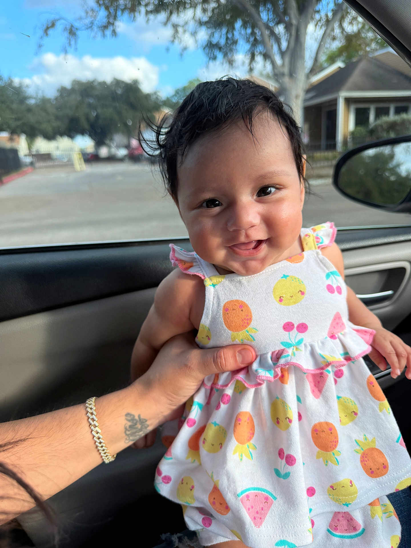 Giselle joined the competition — help win amazing prizes! baby, smiling, child, dress, fruit_pattern, car_interior, hand, tattoo, bracelet, window, daylight, portrait, cute, happy, young_child, person, seat, clothing, skin, hair