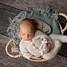 newborn, baby, sleeping, basket, knitted_outfit, teddy_bear, blanket, wooden_floor, cozy, infant, cute, resting, child, soft_texture, peaceful, portrait, hand, foot, indoor, laying