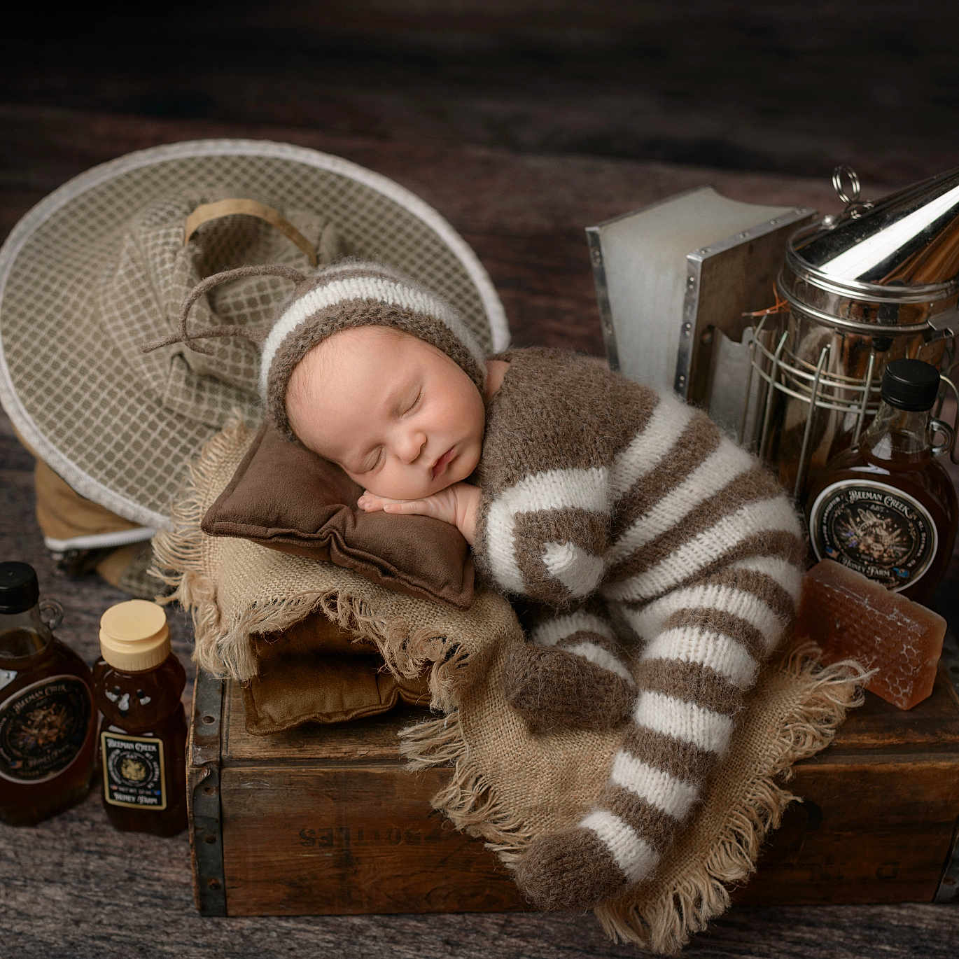 Greylan joined the competition — help win amazing prizes! baby, beekeeper_hat, burlap, cozy, honey_bottle, indoors, infant, knitwear, metal_smoker, newborn, peaceful, pillow, portrait, resting, rustic, sleeping, soft_lighting, striped_outfit, vintage, wooden_crate