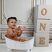 Kendrys is registered to the contest to win money with this photo: baby, child, bathtub, clawfoot_tub, orange_slices, clapping, happy, smiling, gold_chain, decorative_wall, blocks, letters, one, indoor, studio, cute, playful, water, skin, portrait