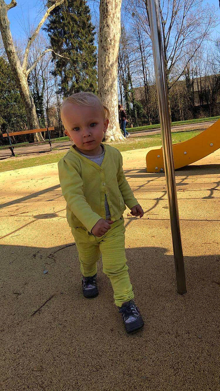 Emmy a rejoint le concours — aidez-le/la à gagner de superbes lots ! asphalt, baby, baby_toddler_clothing, city, fun, grass, leaf, leisure, outdoor_play_equipment, person, plant, play, playground, recreation, shade, sky, soil, swing, toddler, tree