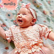 Amiyah is registered to the contest to win money with this photo: baby, child, infant, smiling, pink_dress, headband, floral_pattern, portrait, cute, happy, laying_down, celebration, milestone, two_months, soft_focus, fabric, clothing, flower, person, newborn