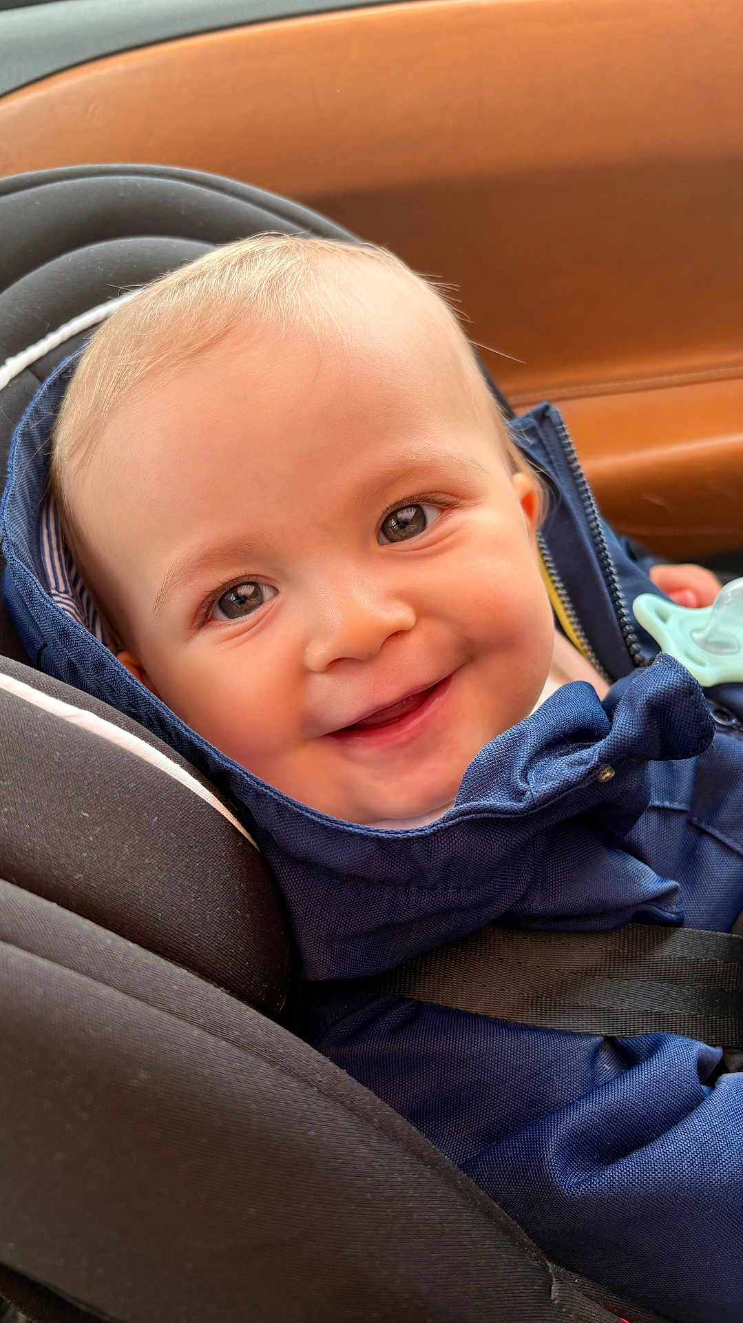Nehoray participe au concours pour gagner de l'argent avec cette photo : baby, blue_clothing, car_seat, child, closeup, cute, eyes, face, happy, head, indoor, infant, jacket, pacifier, person, portrait, seatbelt, skin, smiling, young_child