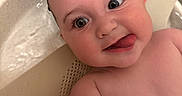 Nova is registered to the contest to win money with this photo: baby, bath, bathtub, child, closeup, cute, expression, face, head, indoors, infant, penguin, playful, selfie, skin, smile, tongue_out, toy, water, wet_hair