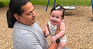 Nova joined the competition — help win amazing prizes! adult, baby, playground, swing, park, grass, trees, child, smile, happy, outdoor, nature, casual_clothing, hair, person, seat, woodchips, accessory, bracelet, watch