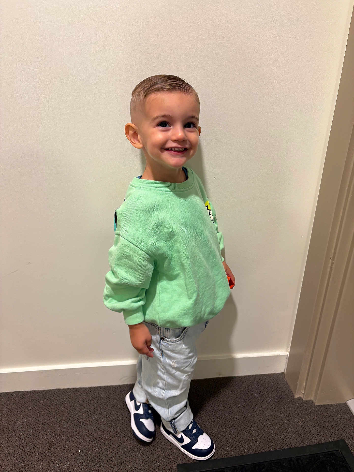 Kinsley a rejoint le concours — aidez-le/la à gagner de superbes lots ! child, boy, smile, standing, mint_green_sweatshirt, light_jeans, sneakers, indoor, carpet, wall, short_hair, happy, casual_clothing, footwear, person, portrait, young_child, full_body, fashion, cute