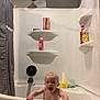 baby, bathtub, bathroom, child, shower, towel, bottle, shelf, curtain, happy, smile, water, skin, head, hand, indoor, plumbing, fixture, person, playful