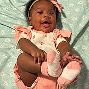 Soni is registered to the contest to win money with this photo: baby, child, infant, smiling, happy, headband, bow, socks, pink, white, floral, patterned_blanket, cute, lying_down, playful, hands, feet, indoors, person, portrait