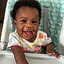 Soni is registered to the contest to win money with this photo: baby, child, high_chair, smiling, happy, face, curly_hair, infant, clothing, patterned, seat_cushion, hand, arm, indoor, portrait, cute, young, person, toddler, expression