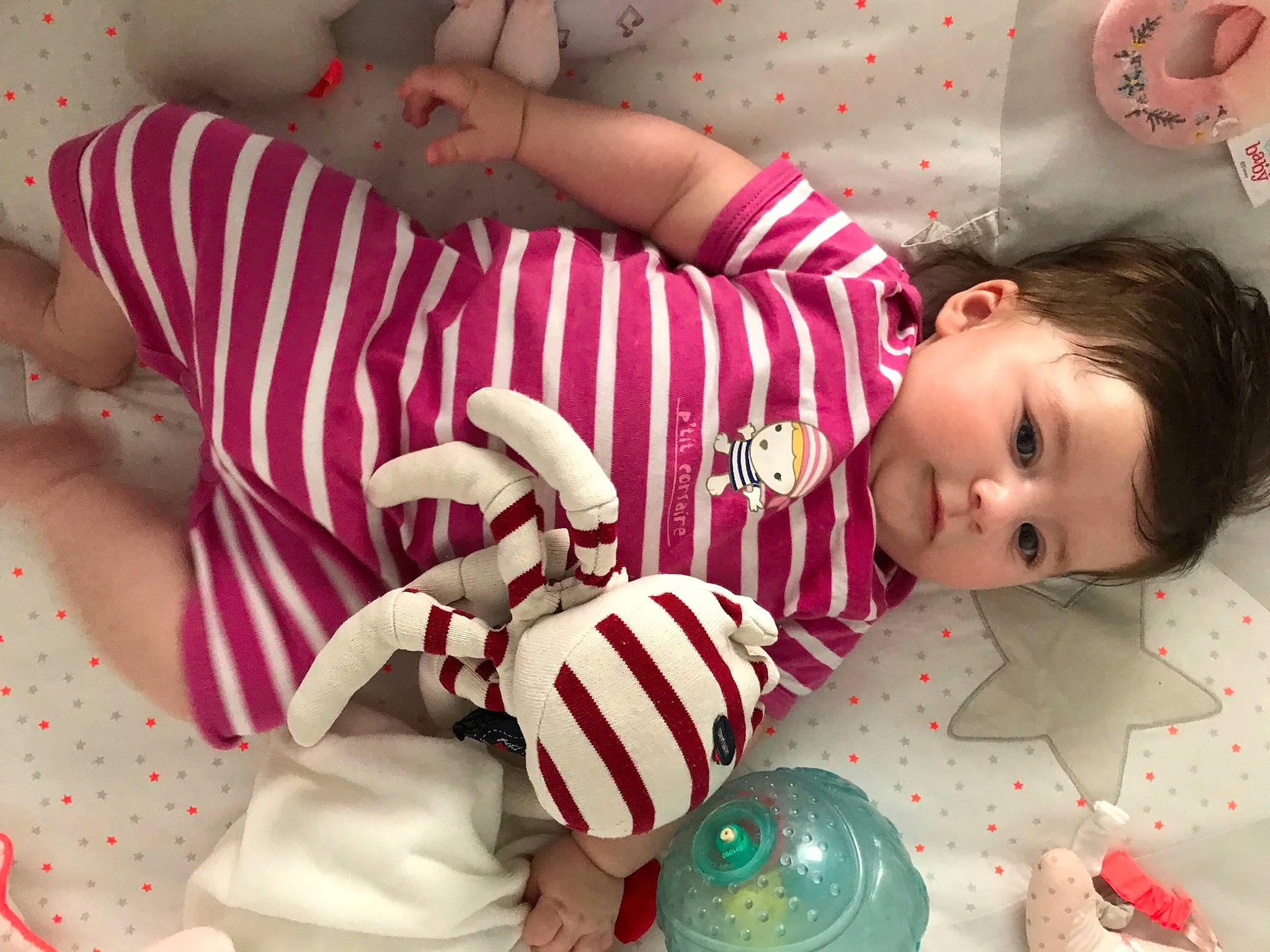 Romy a rejoint le concours — aidez-le/la à gagner de superbes lots ! baby, baby_toddler_clothing, child, comfort, happy, head, human_body, human_leg, linens, mouth, pattern, person, pink, product, red, skin, textile, thigh, toddler, toy