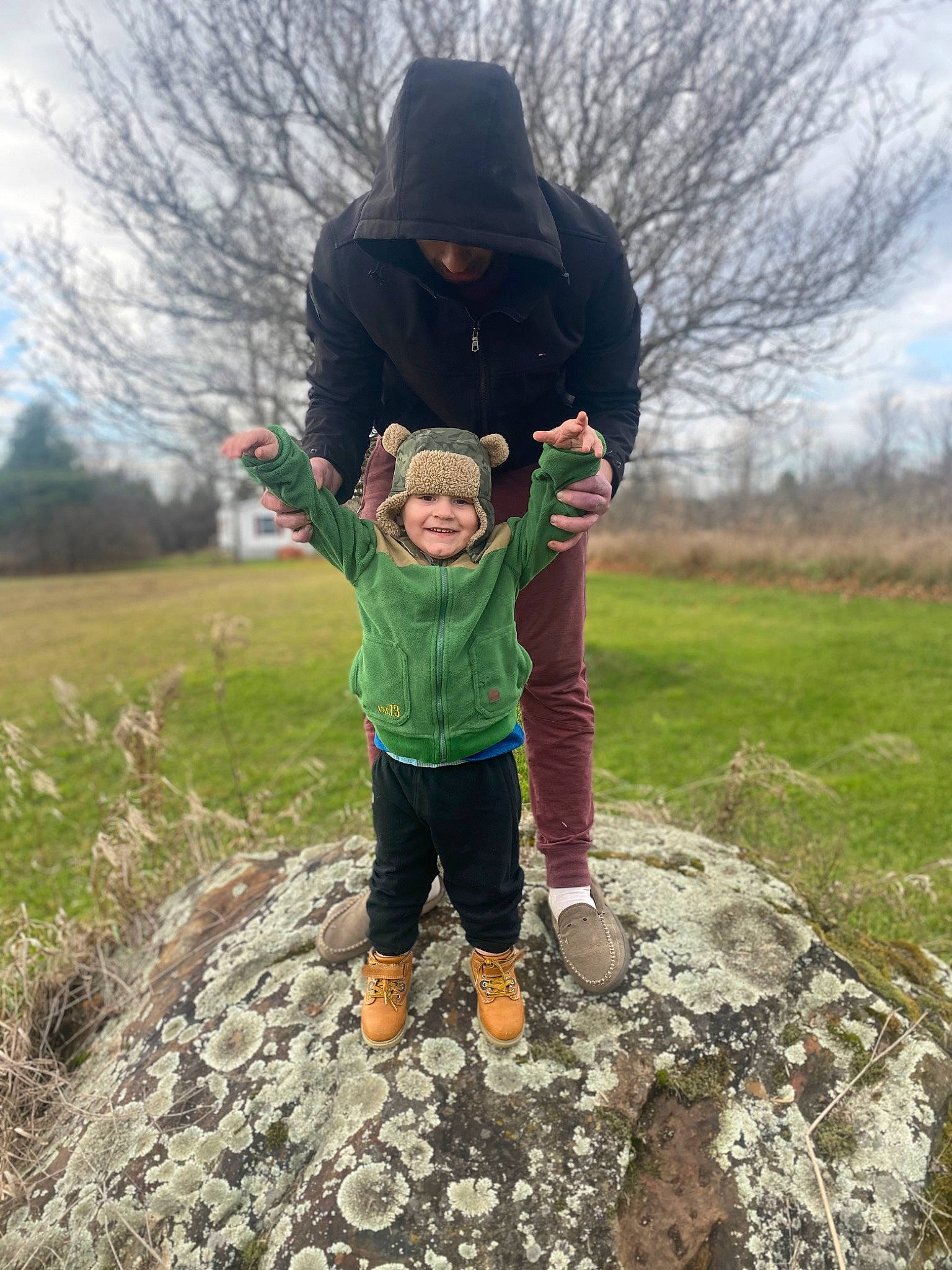 Kyle is registered to the contest to win money with this photo: boot, child, fun, grass, grassland, happy, hat, headwear, jacket, joy, landscape, leisure, people_in_nature, person, plant, recreation, shoe, sky, sneakers, soil