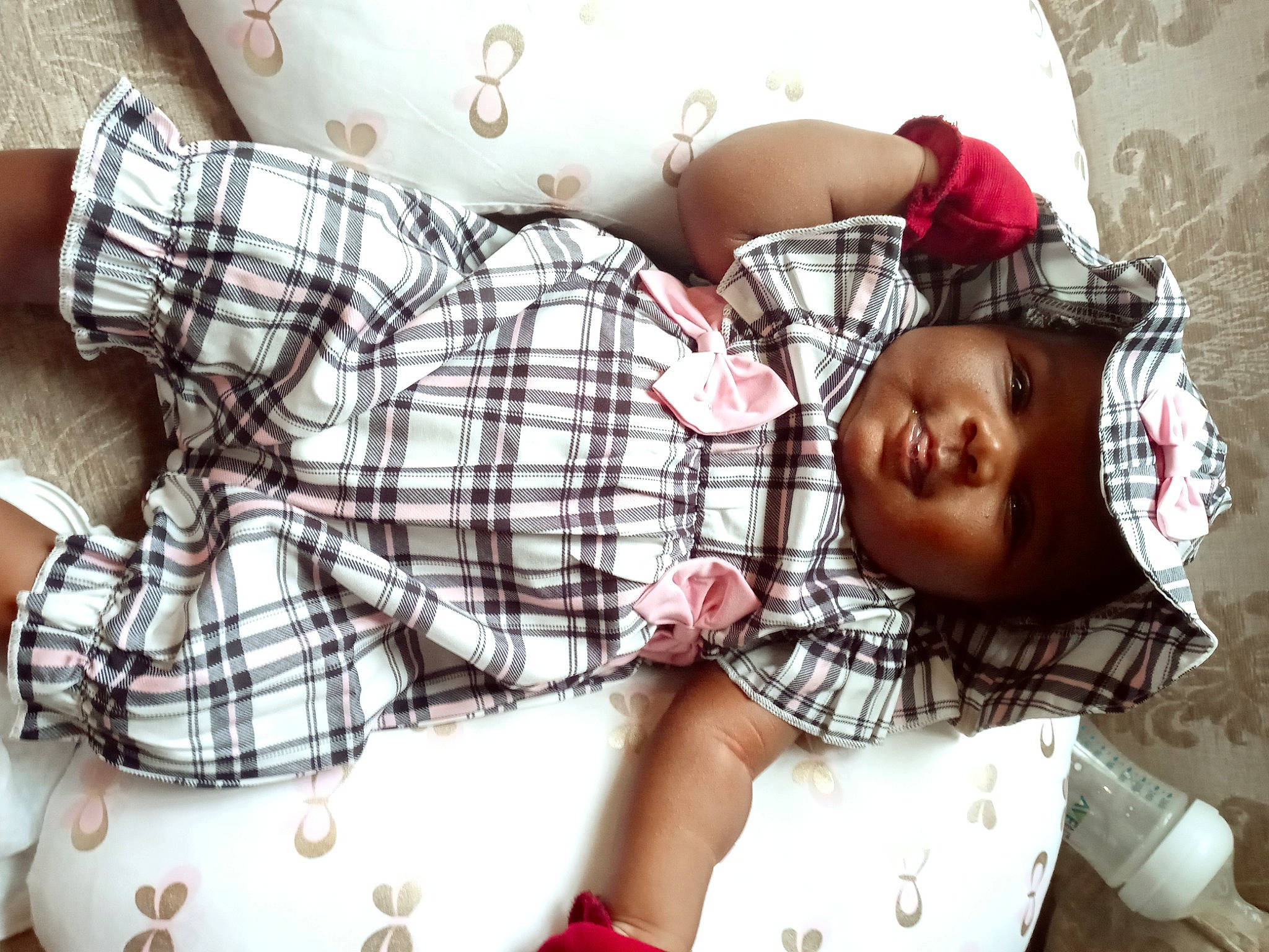 Imani is registered to the contest to win money with this photo: abdomen, baby, bedding, bedtime, child, comfort, happy, headwear, human_leg, linens, nap, pattern, person, plaid, room, sitting, sleep, tartan, textile, thigh