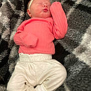 Ivory is registered to the contest to win money with this photo: newborn, baby, sleeping, infant, clothing, pink_sweater, white_pants, headband, blanket, patterned_blanket, cozy, cute, child, person, resting, small, indoor, soft, portrait, baby_clothes