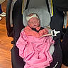 Ivory is registered to the contest to win money with this photo: baby, newborn, infant, car_seat, pink_blanket, headband, pacifier, sleeping, child, indoors, wood_floor, blanket, clothing, seat, person, cute, resting, baby_accessory, safety, peaceful