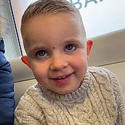 Hugo participe au concours pour gagner de l'argent avec cette photo : child, boy, smile, sweater, indoor, portrait, window, face, happy, young, person, casual, cute, knitwear, seated, light, blond_hair, blue_eyes, cozy, candid