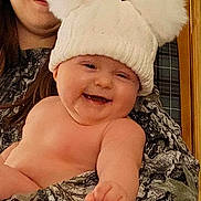 Ivaria is registered to the contest to win money with this photo: baby, child, woman, glasses, hat, pom_poms, smile, laughing, indoor, person, holding, warm_clothing, face, skin, portrait, happiness, cozy, pointing, headwear, family