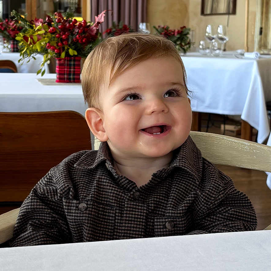 Gaspard participe au concours pour gagner de l'argent avec cette photo : baby, child, clothing, curtain, decor, dining, face, flower_arrangement, furniture, glasses, happy, indoor, lamp, portrait, restaurant, smiling, table, toddler, window, wooden_chair