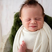 Oliver is registered to the contest to win money with this photo: newborn, baby, infant, smiling, wrapped, blanket, cozy, cushion, wooden_cradle, peaceful, sleeping, soft, cute, face, portrait, indoors, resting, happy, child, toddler