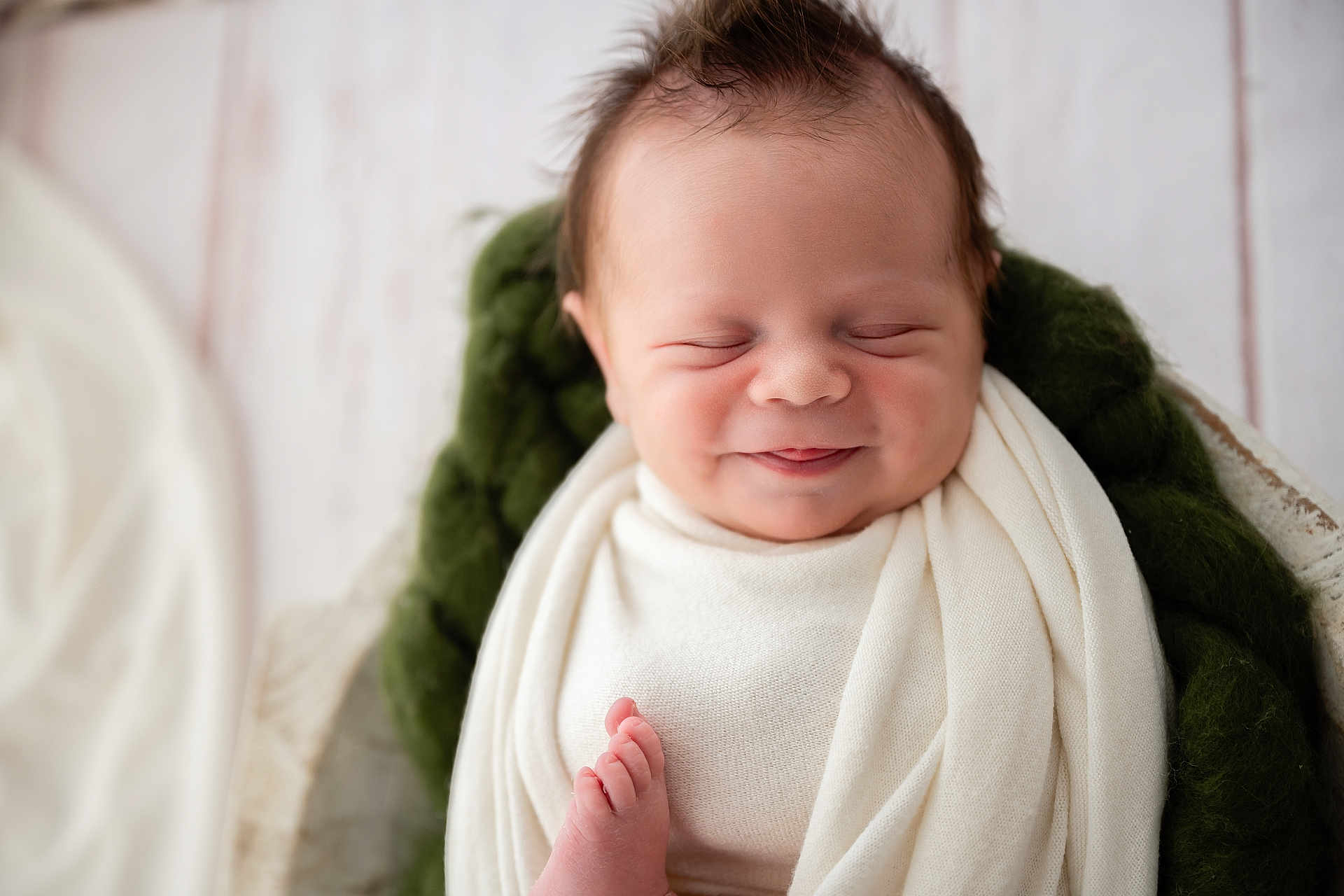 Oliver is registered to the contest to win money with this photo: newborn, baby, infant, smiling, wrapped, blanket, cozy, cushion, wooden_cradle, peaceful, sleeping, soft, cute, face, portrait, indoors, resting, happy, child, toddler