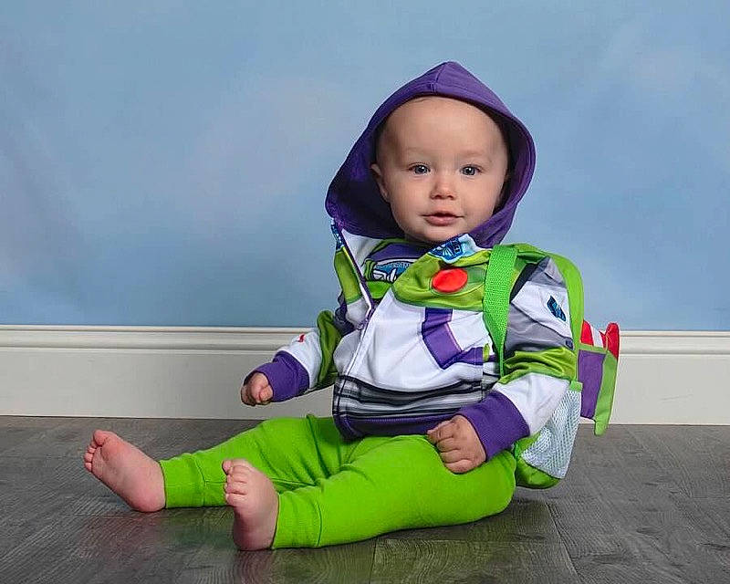 Mars is registered to the contest to win money with this photo: baby, child, fictional_character, hood, outerwear, person, play, purple, sitting, sleeve, toddler, violet